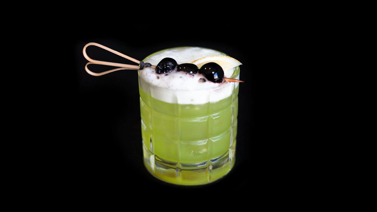 Cocktail Midori Sour con limone e ciliegie marschino
