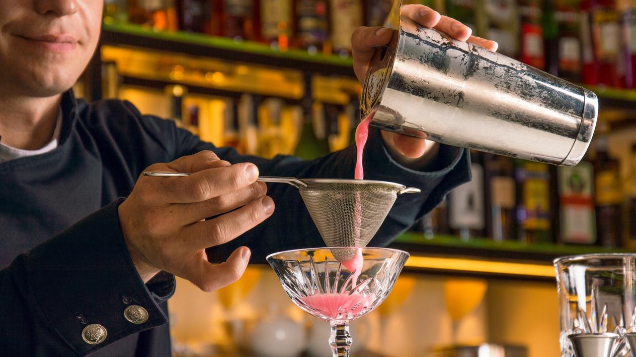 bartender straining cocktail