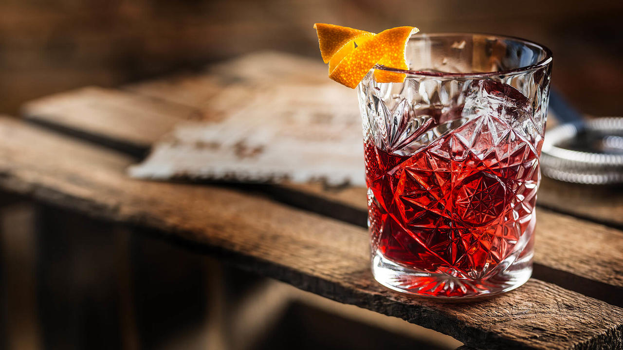 Negroni-cocktail-in-crystal-glass-on-wooden-table