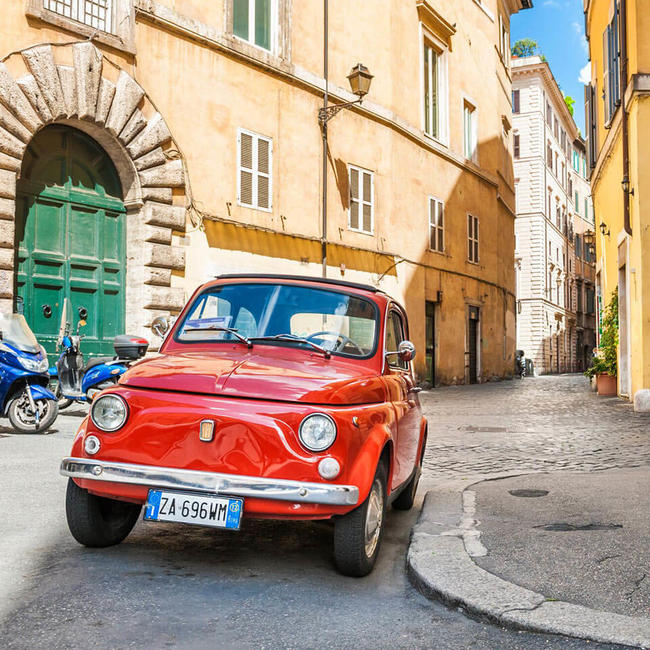 red classic car parked in a picturesque street in rome