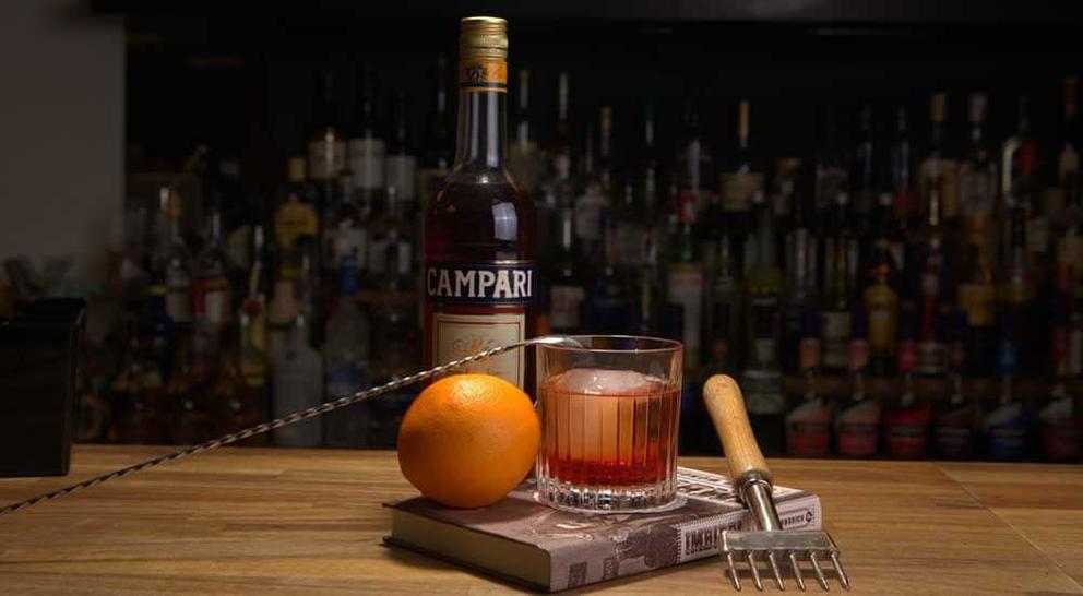 orange-and-bottle-of-campari-ingredients-for-a-negroni